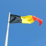 a black, yellow and red flag flying in the sky