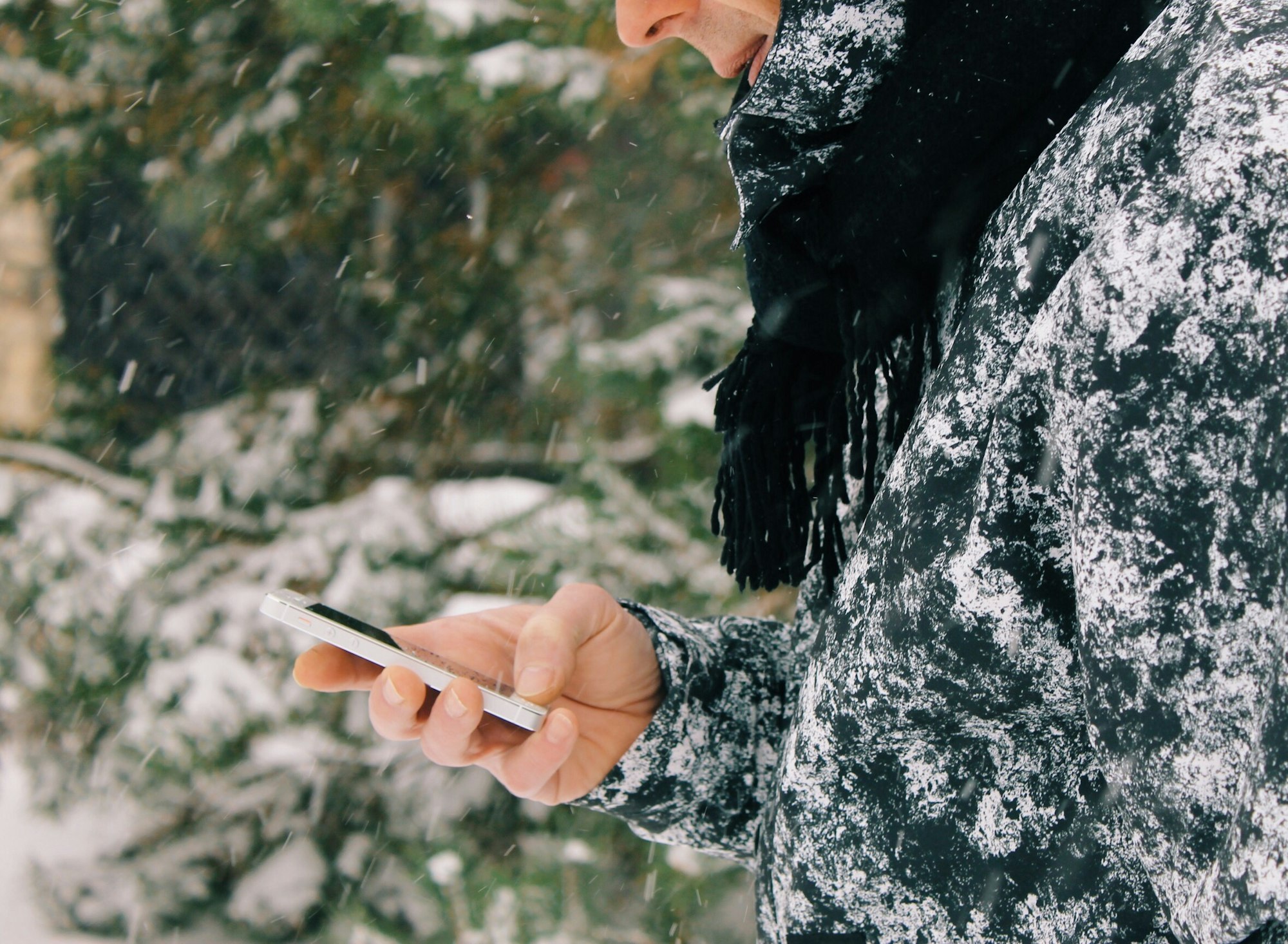 Man texting on a phone in the snowy day