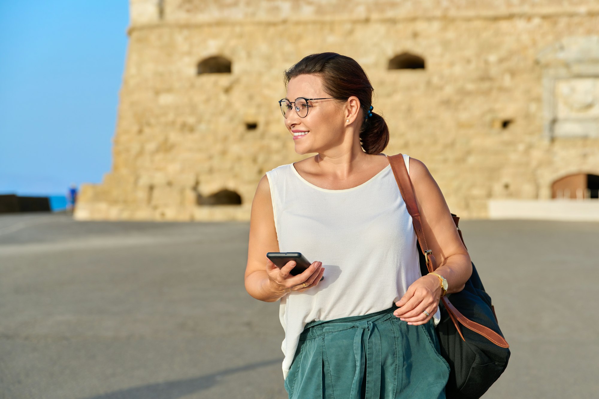 Outdoor portrait of smiling middle-aged woman walking through an old town