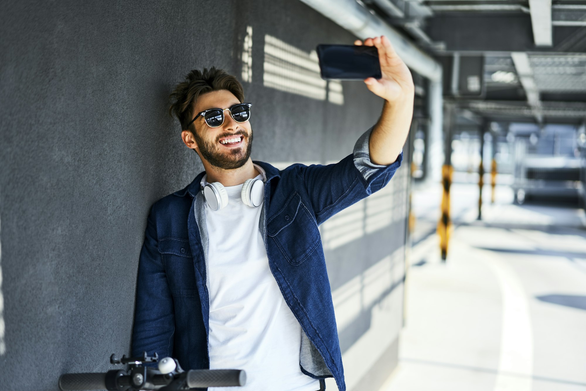 Portrait of smiling man taking selfie with smartphone