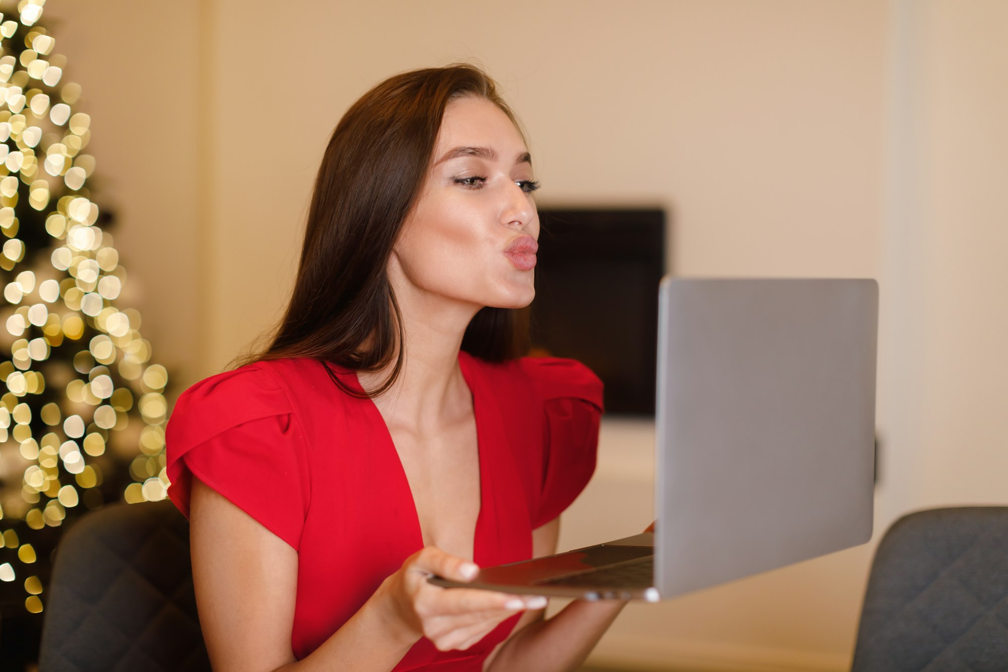 Woman blowing kiss during virtual date on laptop