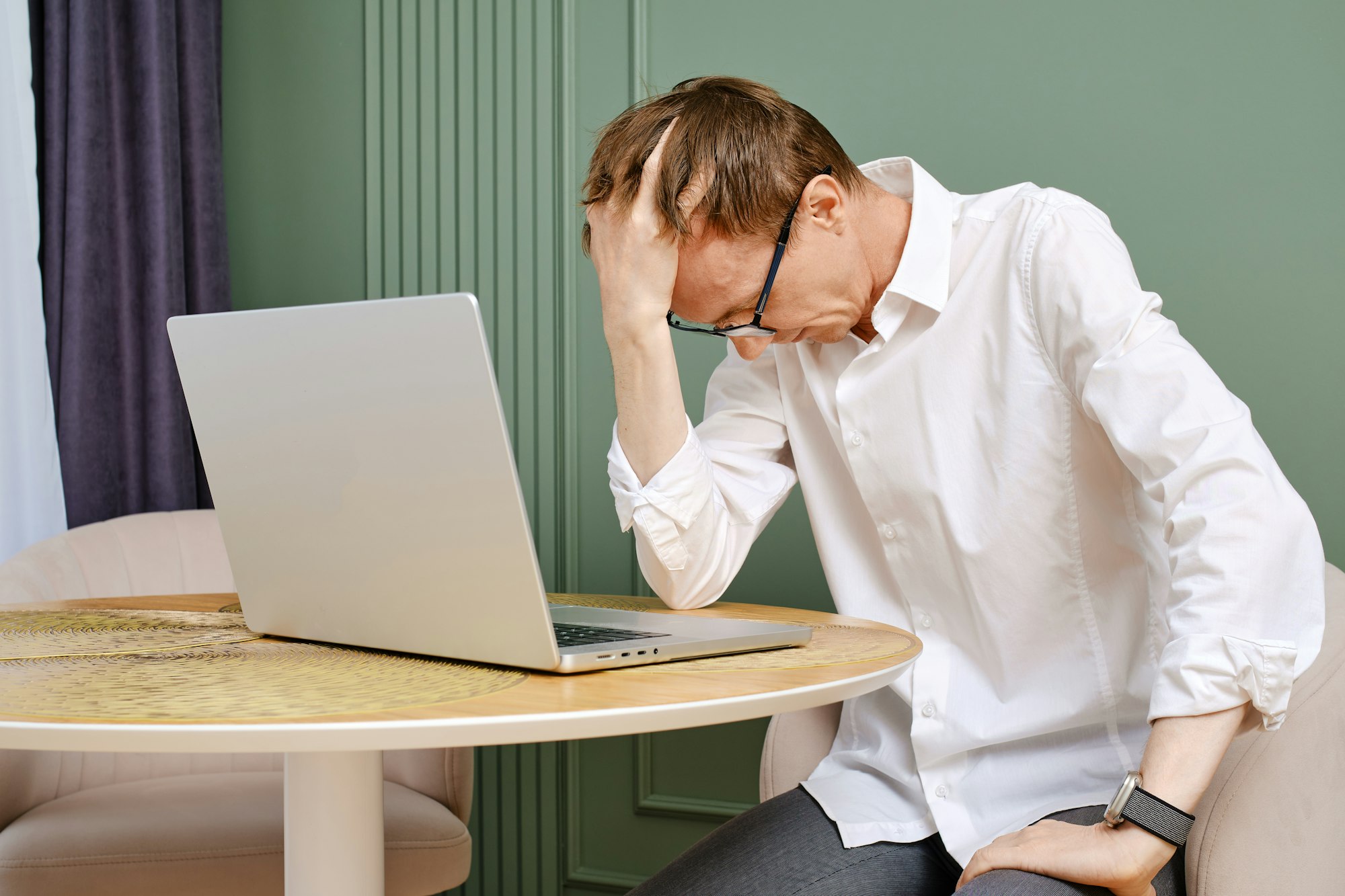 Upset and tired middle aged man with laptop